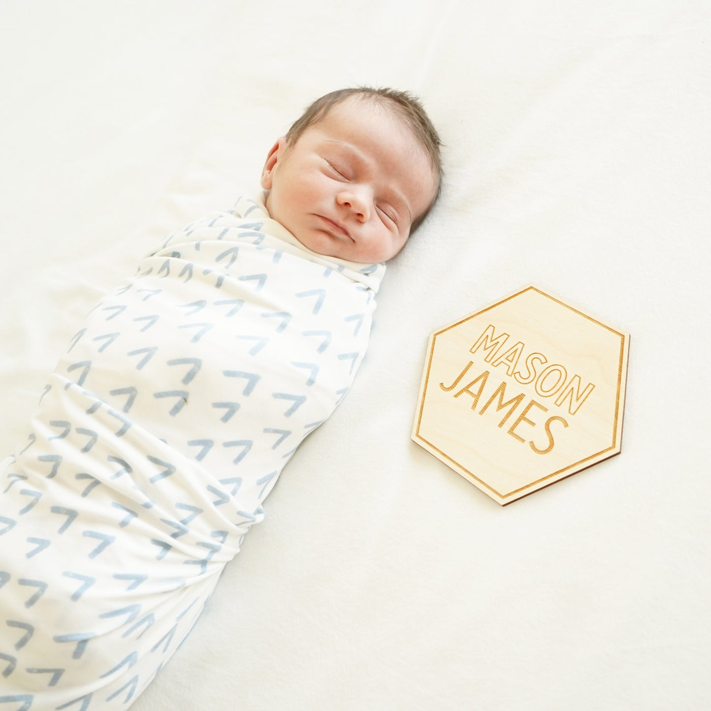 baby boy in sweet peak swaddle with hexagon name sign