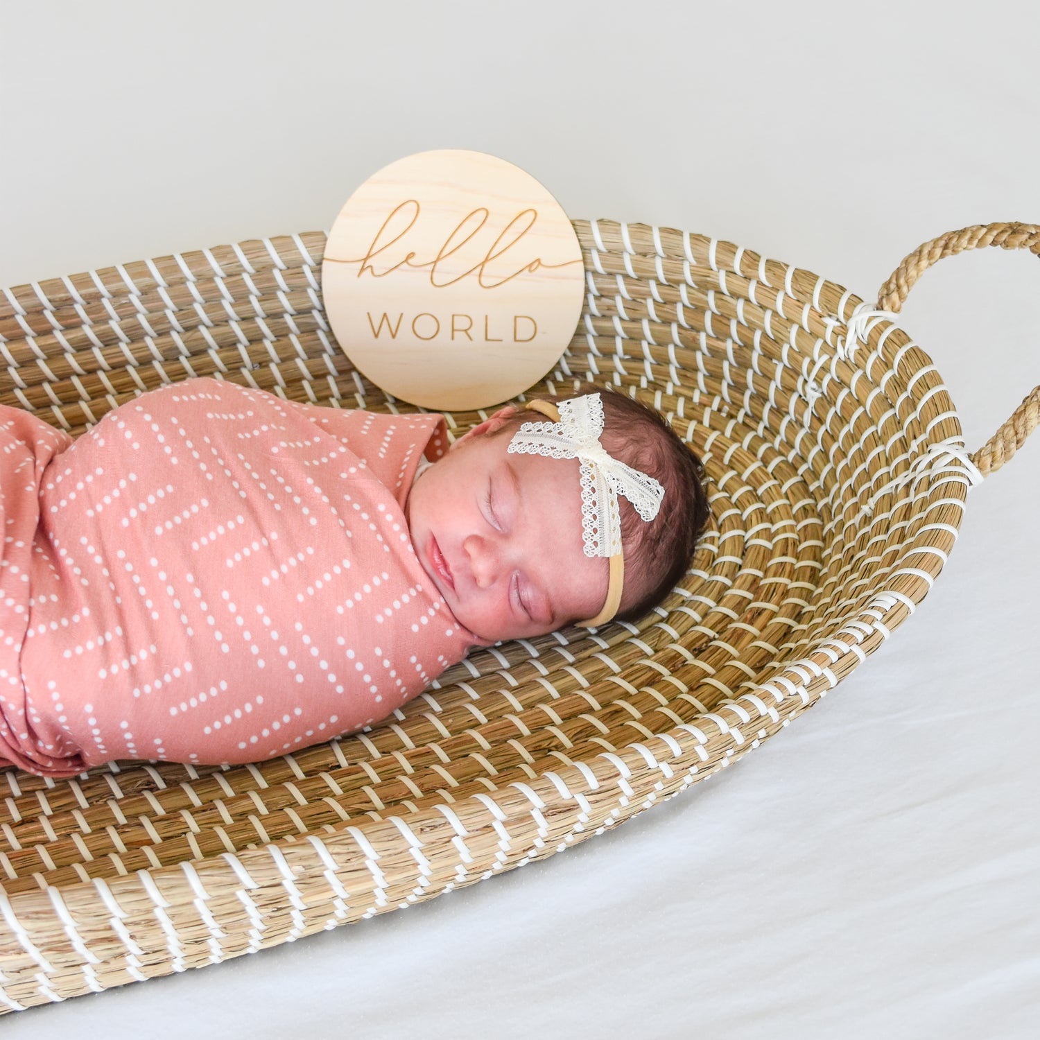 baby hello world sign with desert dots swaddle and ivory june bow headband in basket