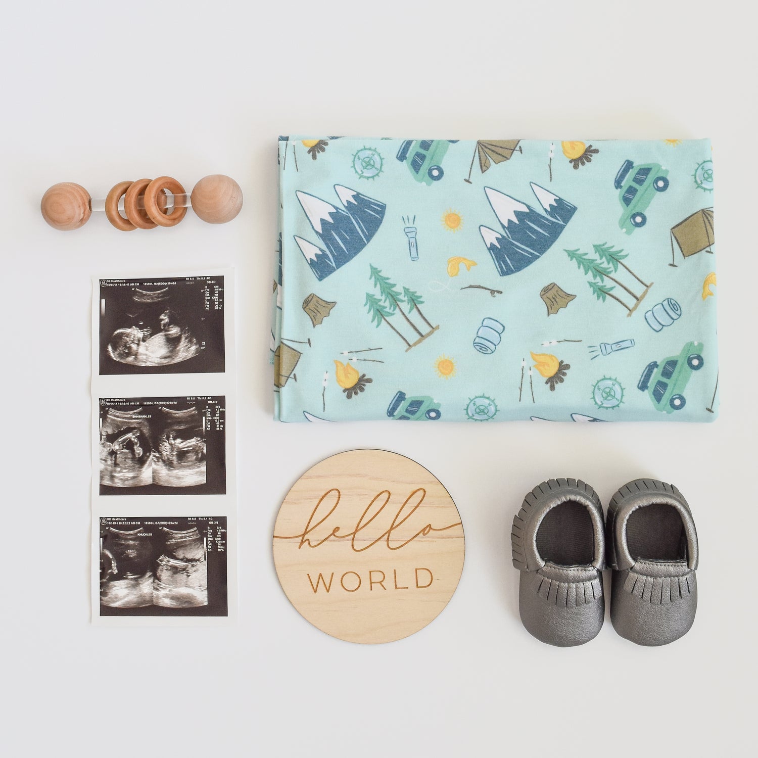 camping outdoor adventure blanket with ultrasound, baby moccasins, and hello world wood sign
