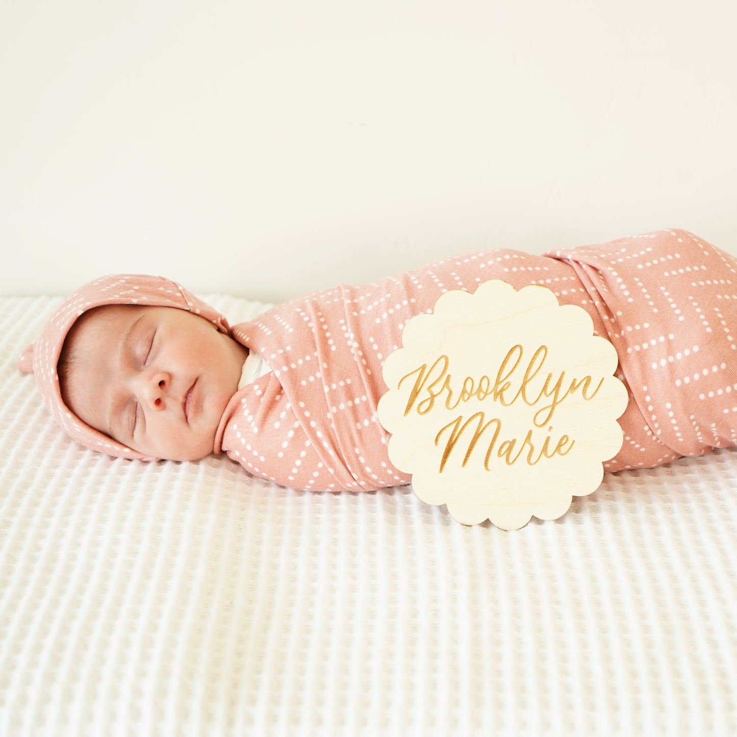 baby in desert dots swaddle and hat set and scalloped custom wood name sign