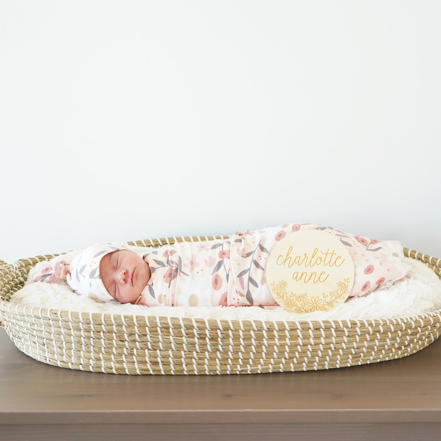 peach posey hat swaddle and custom sign set with baby in basinet in nursery