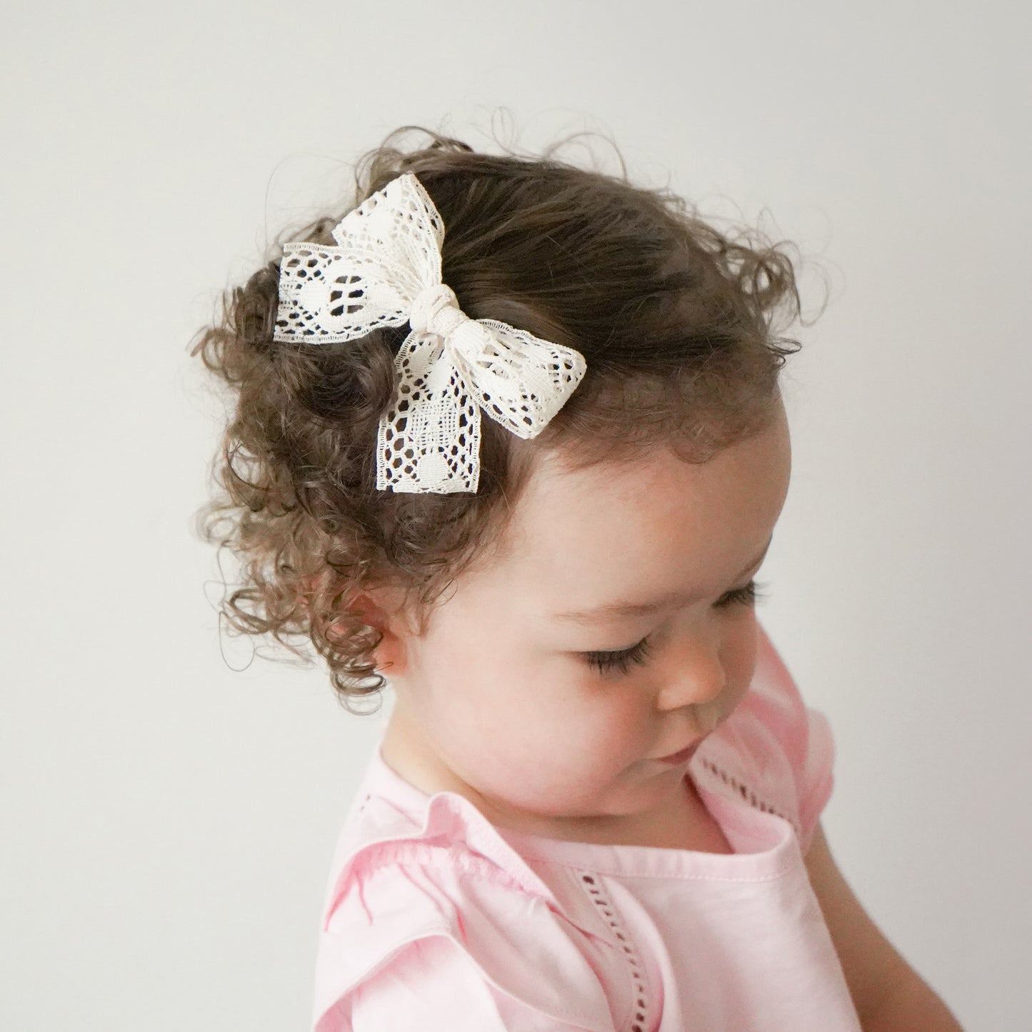 Toddler wearing Abigail lace ivory cream off white bow