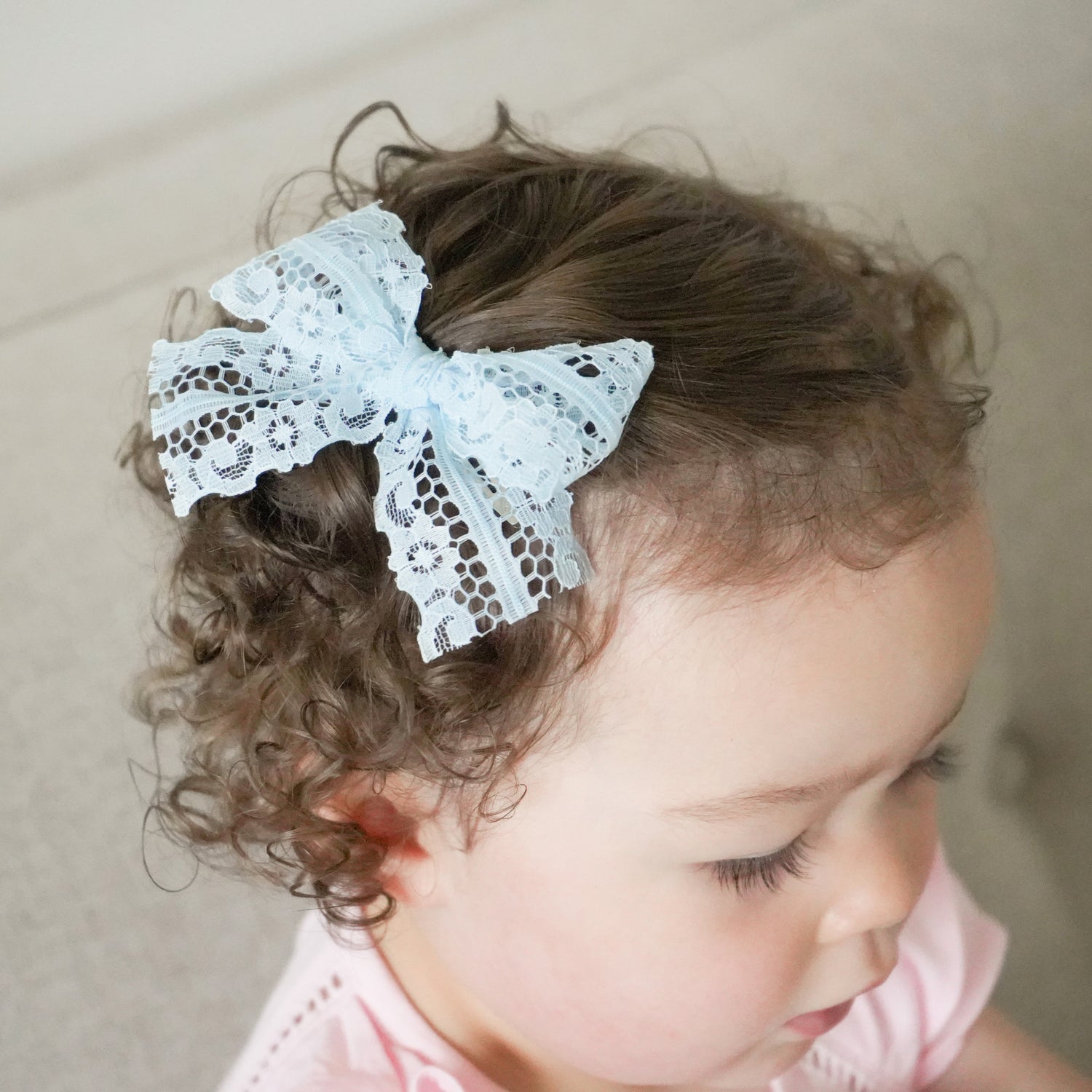 toddler girl with light blue Reese lace clip in bow
