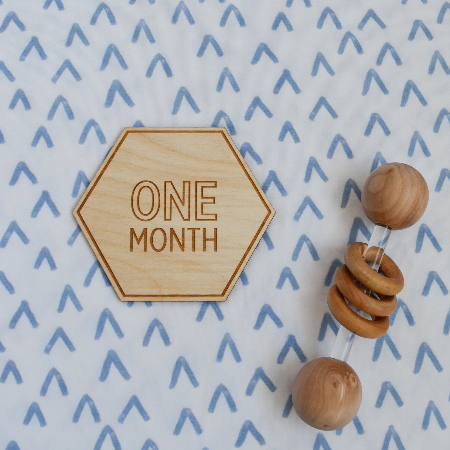 one month sign and rattle on sweet peaks swaddle stretch knit blanket