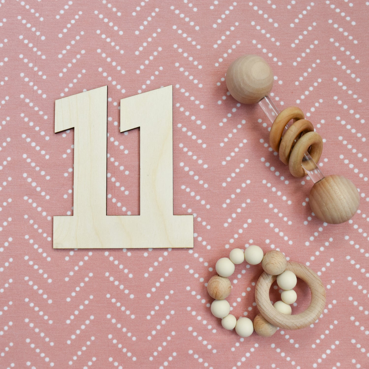 number eleven with wooden rattles on 1st colored blanket for baby