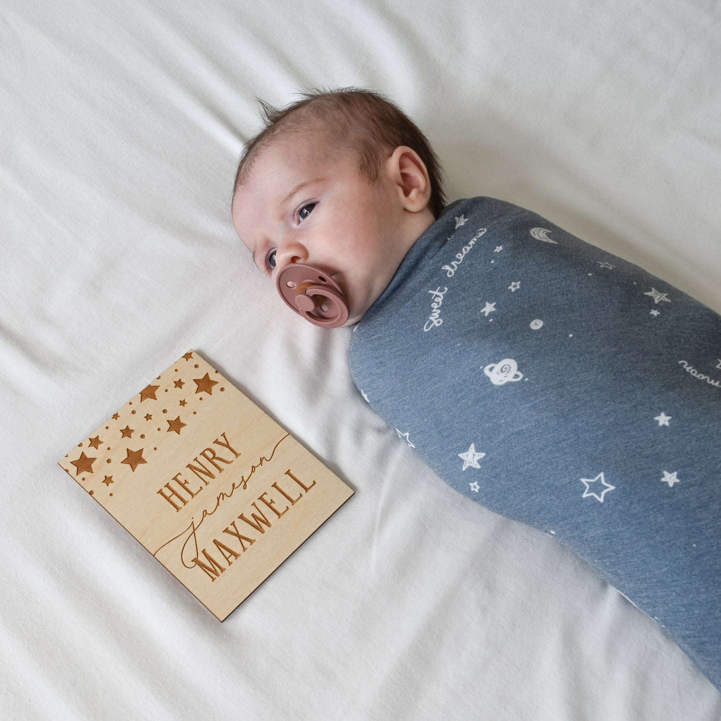 baby boy in stars navy blue baby blanket with pacifier and wooden name birth announcement