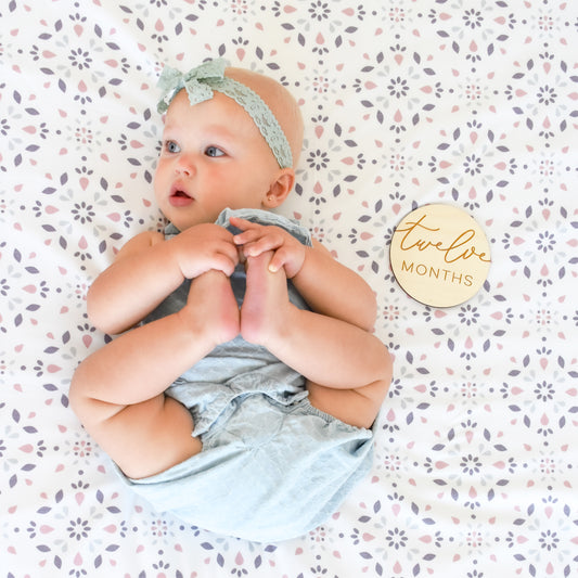 baby with twelve month milestone sign pattern blanket lace headband photography